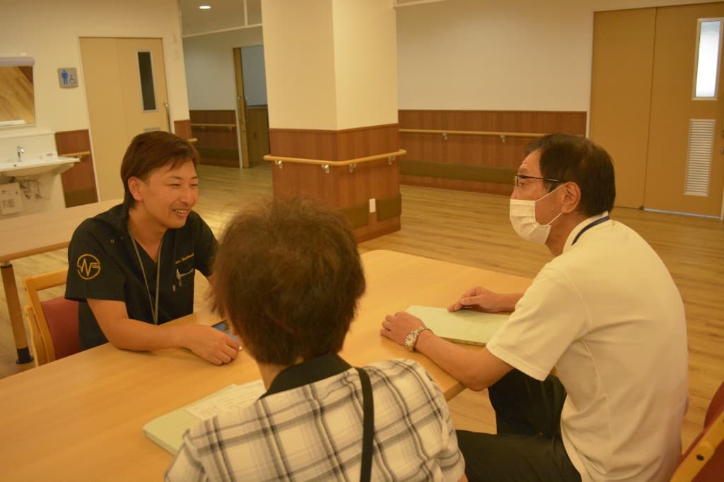 施設職員と専門職が書類を見ながら加算支援について打ち合わせをしている様子